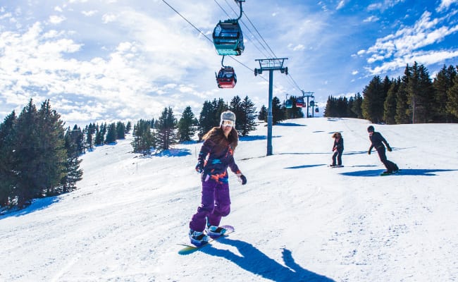 Woman snowboarding down slope at Ski Apache in New Mexico.