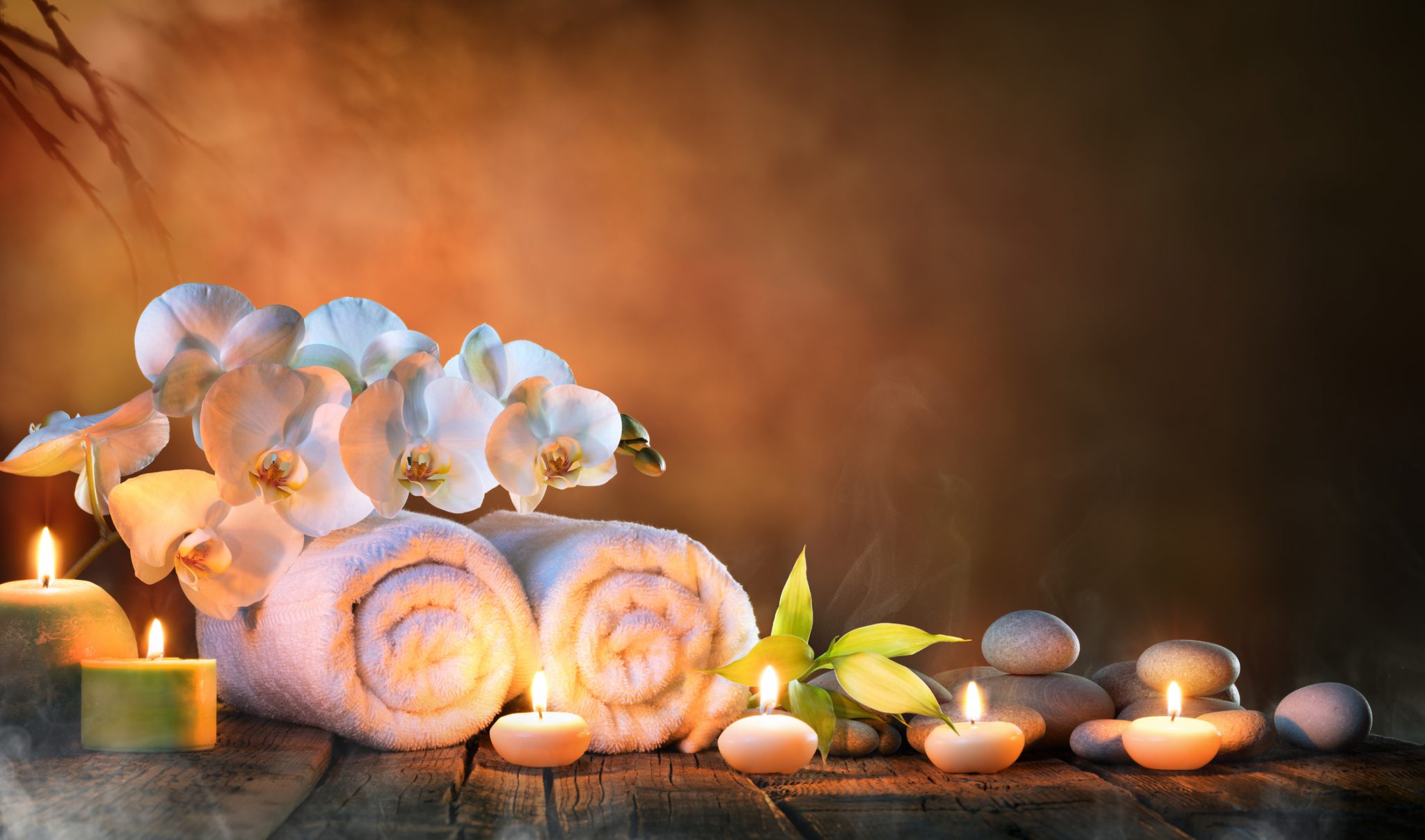 White flowers, rolled up towels, hot stones, and lit candles.