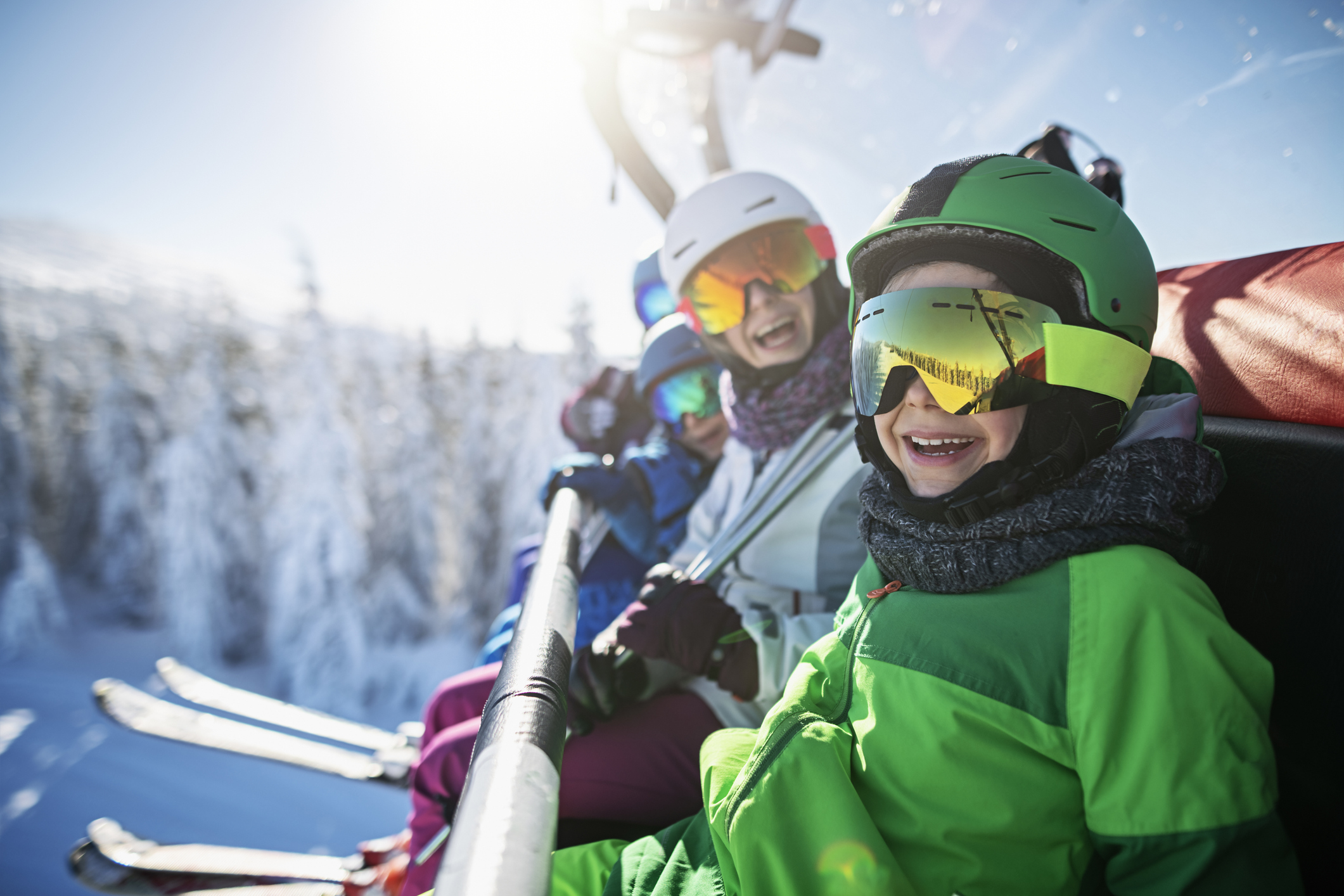 Family enjoying skiing on sunny winter day.