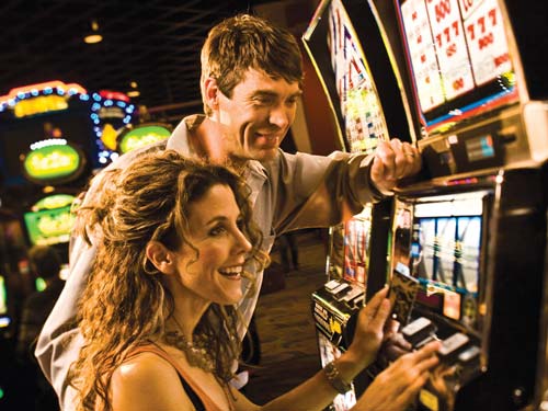 Couple playing slots at Inn of the Mountain Gods Casino.